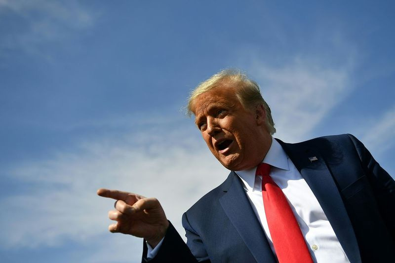 Na tejto archívnej fotografii sa prezident USA Donald Trump prihovára členom médií po prílete na medzinárodné letisko Phoenix Sky Harbor vo Phoenixe v Arizone 19. októbra 2020.
