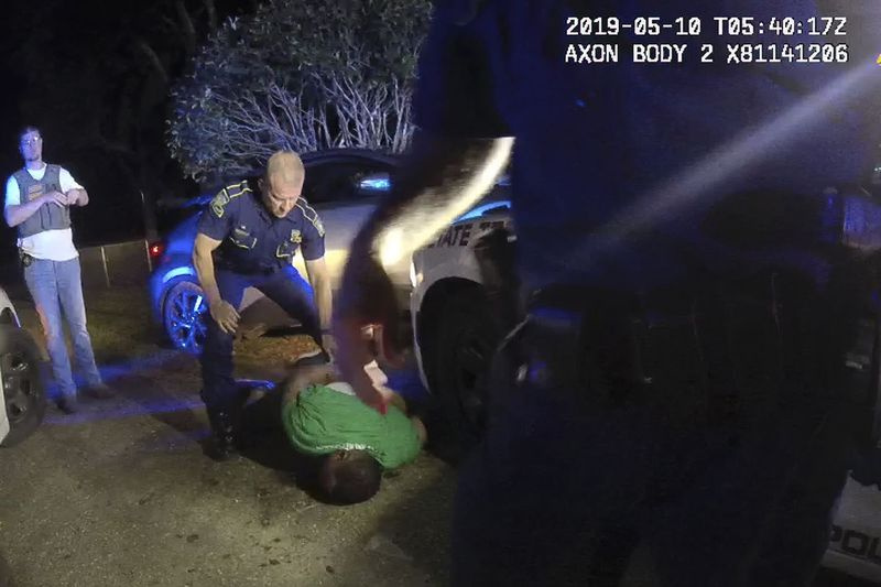 Esta imagen del video de la cámara corporal del policía estatal de Louisiana, el teniente John Clary, muestra al policía Kory York parado boca abajo sobre Ronald Greene el 10 de mayo de 2019, en las afueras de Monroe, Luisiana.