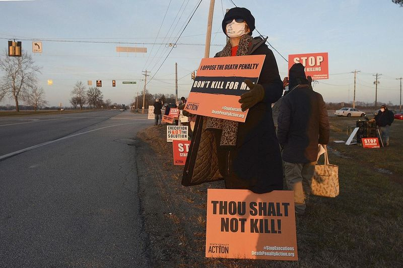 Karen Burkhart tient une pancarte en face du Complexe correctionnel fédéral de Terre Haute, Indiana, pour protester contre l