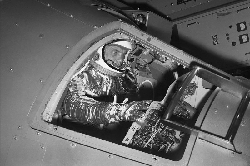 På dette arkivfoto fra 11. januar 1961 rækker marineløjtnant oberst. John Glenn ud efter kontroller inde i en Mercury-kapsel-proceduretræner, da han viser, hvordan den første amerikanske astronaut vil ride gennem rummet under en demonstration ved National Aeronautics and Space Administration Research Center i Langley Field, Va.