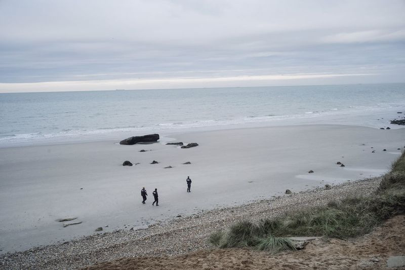 Franske politibetjente patruljerer på stranden i søgemigranterne i Wimereux, det nordlige Frankrig, onsdag den 17. november 2021. Adskillige migranter døde og andre blev såret onsdag 24. november 2021, da deres båd kæntrede ud for Calais i Den Engelske Kanal, da de forsøgte at krydse fra Frankrig til Storbritannien, sagde myndighederne.