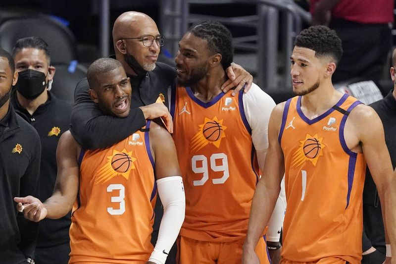 Hlavný tréner Phoenix Suns Monty Williams, druhý zľava, objíma Chrisa Paula (vľavo) a Jaea Crowdera (druhého sprava), zatiaľ čo Devin Booker stojí vedľa.