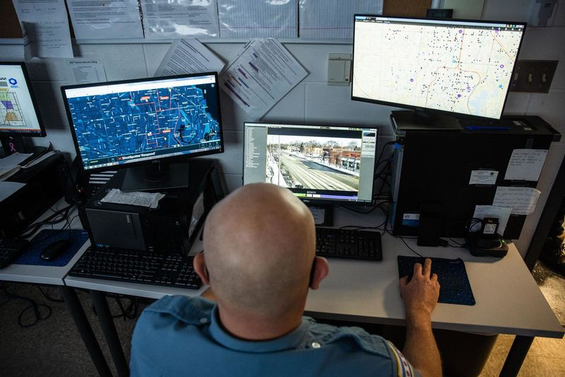 Policijos pareigūnas Johnas Thillas stebi kameras, esančias aplink 19-ąją palatą iš Morgan Parko rajono Strateginių sprendimų paramos centro.
