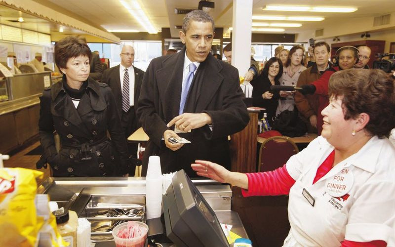 Barack Obama - takrat izvoljeni predsednik - se pripravlja na plačilo, medtem ko njegova svetovalka Valerie Jarrett opazuje med postankom v Mannyjevem dogodku 21. novembra 2008. Fotografija iz datoteke AP