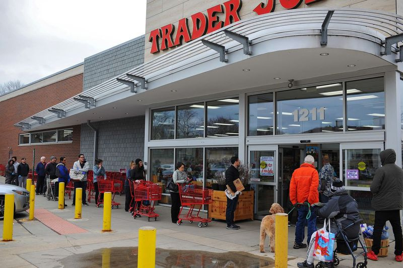 Nakupující se seřadí, aby se v pátek 20. března 2020 dostali do obchodu Trader Joe’s v Evanstonu, IL.