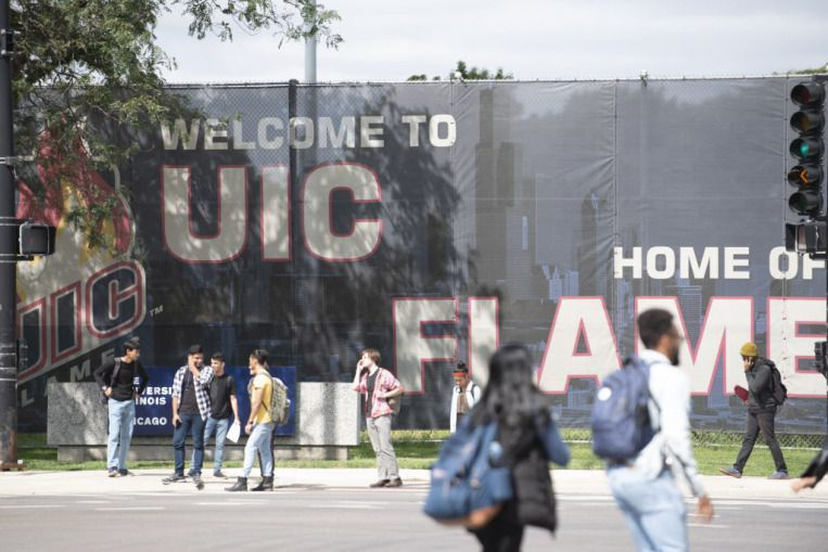 Fotgängare går förbi skyltar för University of Illinois på Chicago campus i Chicago den 10 september 2018. | Colin Boyle/Sun-Times