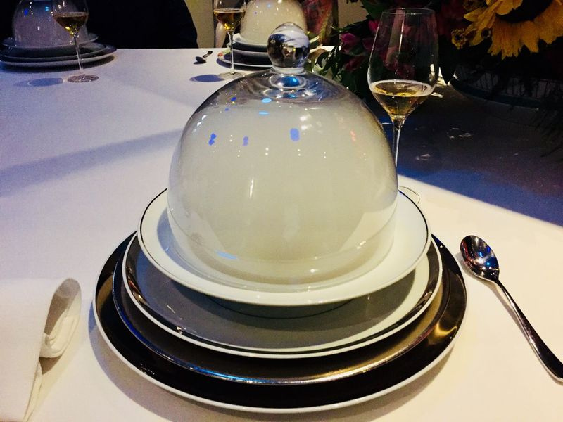 Una zuppa di pastinaca con caviale di osetra ricoperta da una cupola contenente fumo di legna, parte dell