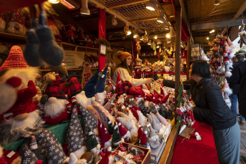   Žena předá v pátek odpoledne 25. listopadu 2022 zaměstnanci kreditní kartu ve stánku Barbarian Tradition na Christkindlmarket v Gallagher Way u Wrigley Field.