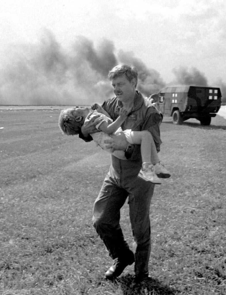 Gwardzista Dennis Nielsen zabiera pasażera Spencera Baileya z dala od wraku samolotu United Airlines Flight 232 po tym, jak samolot rozbił się na lotnisku Sioux Gateway w Sioux City w stanie Iowa 19 lipca 1989 r. Zdjęcie pliku AP