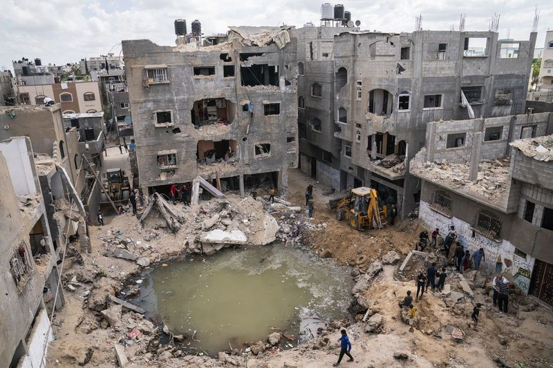 Un cráter lleno de agua y aguas residuales permanece donde una casa destruida por un ataque aéreo en el norte de la Franja de Gaza.