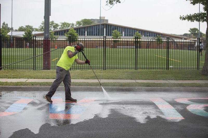 Landsbyansatte fra Oak Park Department of Public Works renser svart maling fra veggmaleriet Black Lives Matter onsdag etter at det ble vandalisert for å lese All Lives Matter. Veggmaleriet er på Scoville Avenue like sør for Lake Street.