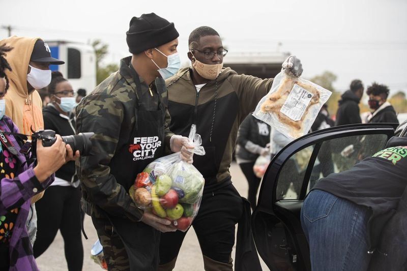 Rapper G Herbo v sobotu rozdává potraviny členům komunity během soutěže Feed Your City Challenge v Pullmanu.