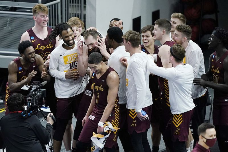 Hráči Loyoly z Chicaga slaví poté, co porazili Illinois ve vysokoškolském basketbalovém zápase ve druhém kole turnaje NCAA v Bankers Life Fieldhouse v Indianapolis neděli 21. března 2021. Loyola naštvala Illinois 71:58.