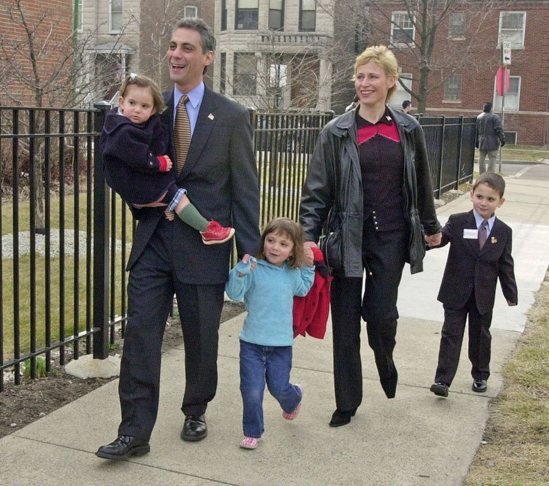 Rahm Emanuel em 2002, a caminho de votar nas primárias de Illinois durante sua primeira candidatura ao Congresso. Caminhando com ele para o ginásio da Courtenay School, 1726 W. Berteau, estavam sua esposa, Amy Rule, com o filho Zach, então com 5 anos, e Ilana, 3. Emanuel está carregando 22-mon