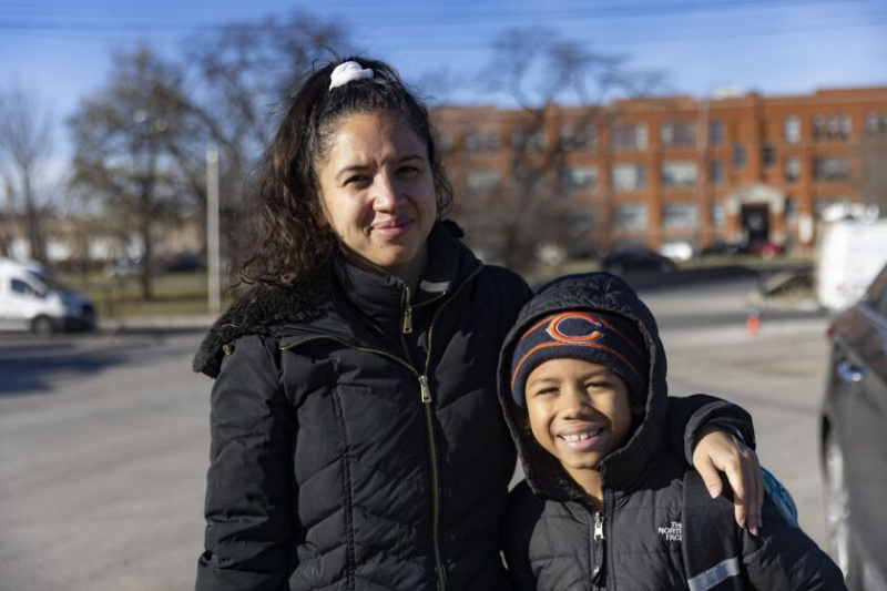   Džeina Riosa un viņas dēls Keidens gaida, lai atgūtu savu transportlīdzekli Čikāgas auto mārciņā 701 N. Sacramento Ave Humbolta parkā, ceturtdien, 2022. gada 1. decembrī.