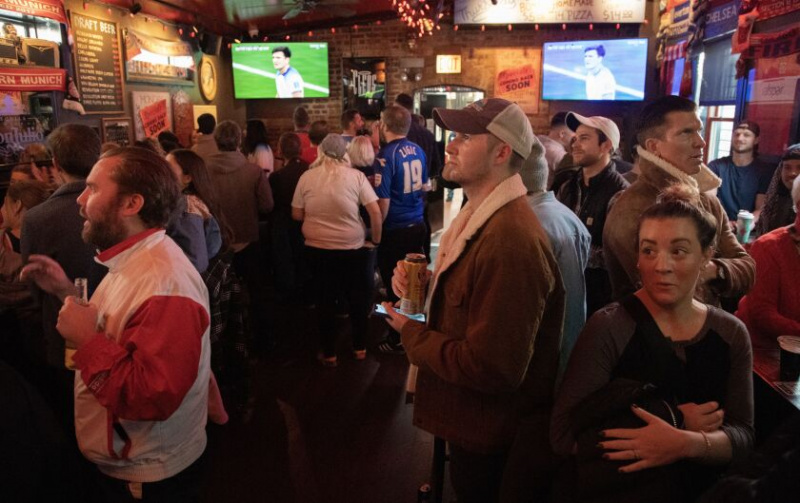   Brandon Feiter (în centru, cu șapcă) urmărește echipa de fotbal masculină a Statelor Unite înfruntând Anglia la Cupa Mondială, vineri, la Cleos, 1935 W. Chicago Ave.