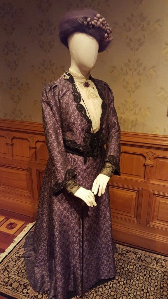 Violet Crawley, Dowager countess of Grantham (Maggie Smith): φόρεμα ημέρας από μετάξι σε μωβ στάμπα, λευκή μπλούζα με παπιγιόν από δαντέλα, κολιέ, καρφίτσα αμέθυστου και καπέλο. |ΦΩΤΟ ΑΠΟ MIRIAM DI NUNZIO/SUN-TIMES
