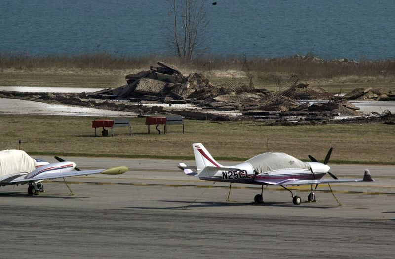 Samoloty są pokazane na mieliźnie w Meigs Field. dzień później buldożery wykopały fragmenty pasa startowego, aby zamknąć lotnisko. W tle widać sterty gruzu z pasa startowego. | Biblioteka Sun-Times