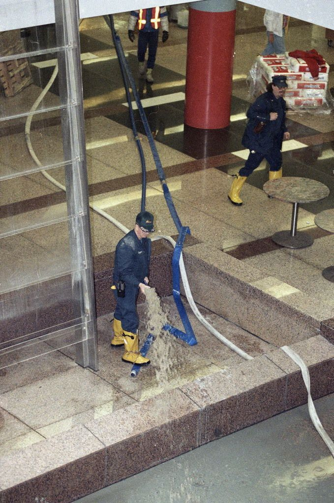 Vanduo iš Ilinojaus valstijos pastato žemesnio lygio išpumpuojamas 1992 m. balandžio 15 d., nes daugelyje pastatų, kurie buvo evakuoti per potvynį, buvo atkurtas elektros tiekimas. | AP