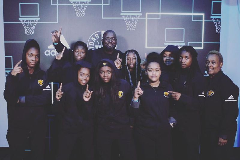 Kierra Moore (segunda desde la derecha), la entrenadora Arlena Wade (extremo derecho) y compañeras de equipo del equipo de baloncesto femenino de Michele Clark Academic Prep Magnet High School.