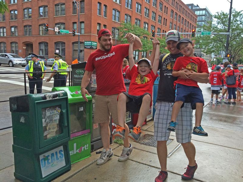 James Wightman, 25, (à esquerda), se junta a seu amigo Brian Nelson, 35, e os filhos de Nelson Caden, 7, (enforcamento) e Chase, 5. Eles são todos de Des Plaines e estavam em Washington e Morgan para assistir ao desfile. | Stefano Esposito / Sun-Times