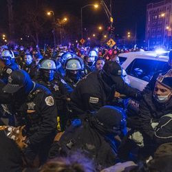 Chicagowska policja i protestujący ścierają się w pobliżu Logan Square Park po pokojowym marszu przez dzielnicę Logan Square w Chicago w piątek, 16 kwietnia 2021 r., w odpowiedzi na zastrzelenie chłopca przez policję w Chicago w zeszłym miesiącu.