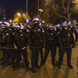 Chicagowska policja ustawia się w kolejce z pałkami po wcześniejszym starciu z protestującymi w pobliżu Logan Square Park w Chicago w piątek, 16 kwietnia 2021 r., dzień po ukazaniu się nagrania wideo, na którym w zeszłym miesiącu chicagowski policjant śmiertelnie zastrzelił 13-latka .