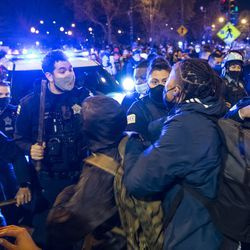 Chicagowska policja i protestujący ścierają się w pobliżu Logan Square Park po pokojowym marszu przez dzielnicę Logan Square w Chicago w piątek, 16 kwietnia 2021 r., w odpowiedzi na zastrzelenie chłopca przez policję w Chicago w zeszłym miesiącu.