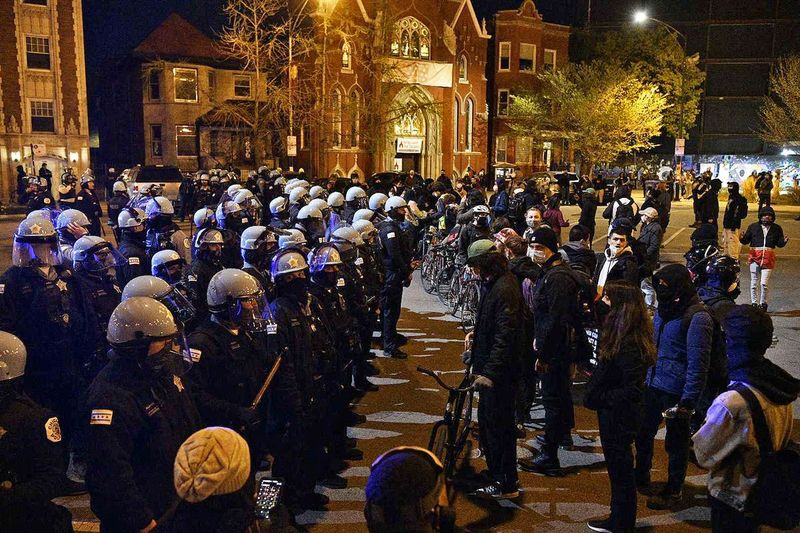 Policja i protestujący na Wrightwood Avenue w pobliżu Logan Square Park w piątek 16 kwietnia 2021 r.