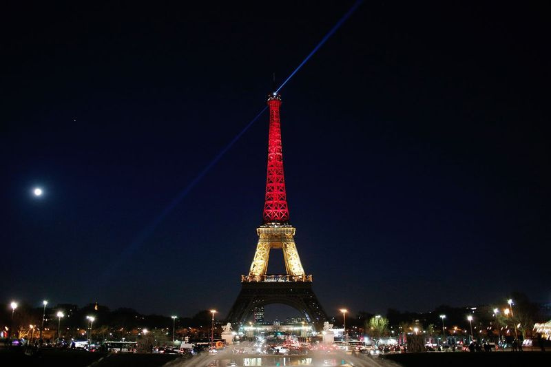 Turnul Eiffel este iluminat cu culorile naționale Belgiei, negru, galben și roșu, în cinstea victimelor atacurilor de astăzi de la aeroport și stația de metrou din Bruxelles. | Thibault Camus/Associated Press