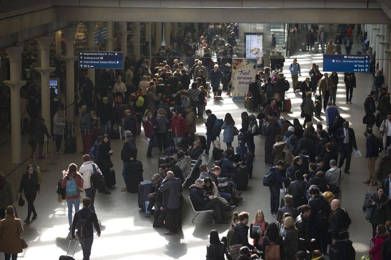 Călătorii stau la coadă la gara St. Pancras din Londra după ce serviciile au fost suspendate pe ruta de tren Bruxelles Eurostar din cauza atacurilor din Belgia. | Matt Dunham/Associated Press