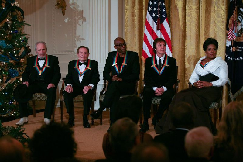 Merle Haggard (levo) se udeleži sprejema v Beli hiši za prejemnike Kennedyjevega centra skupaj z Jerryjem Hermanom, Billom T. Jonesom, Paulom McCartneyjem in Oprah Winfrey leta 2010. | Gary Fabiano/Getty Images
