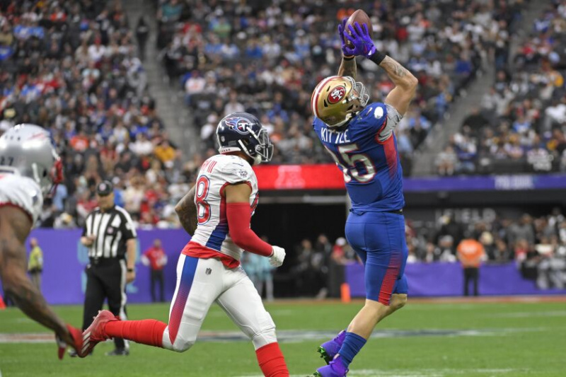   Pevný NFC George Kittle, vpravo, zo San Francisco 49ers, chytil prihrávku pred vonkajším obrancom AFC Haroldom Landrym, vľavo, z Tennessee Titans, počas prvej polovice minulej sezóny Pro Bowl.
