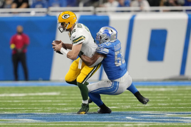  Rozohrávač Packers Aaron Rodgers je prepustený linebackerom Lions Derrickom Barnesom.