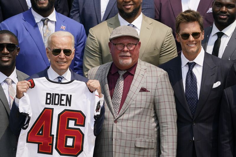 President Joe Biden seisab Valges Majas koos Tampa Bay Buccaneersi tagamängija Tom Bradyga paremal ja treener Bruce Ariansiga.