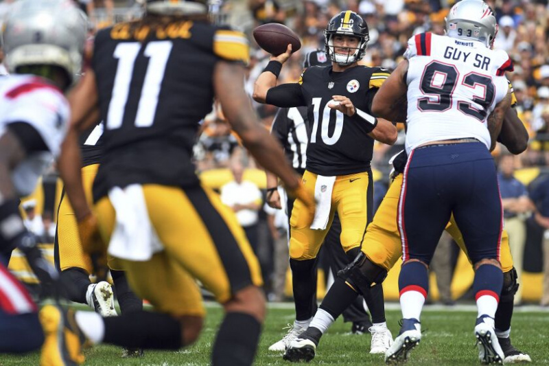   Pittsburgh Steelers quarterback Mitch Trubisky (10) kaster en pasning til Chase Claypool (11) under første halvdel av søndagens kamp mot New England Patriots.