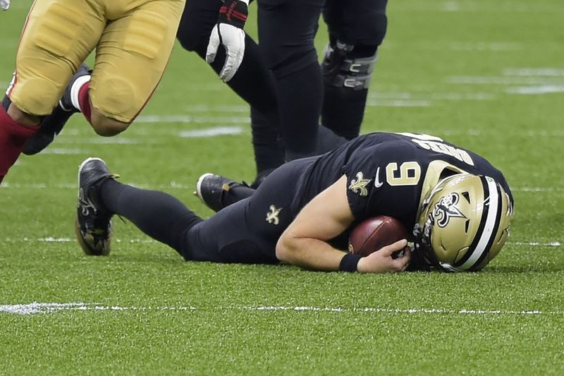 Saints quarterback Drew Brees ligger kvar på marken efter att ha blivit sparkad av 49ers Kentavius ​​Street. Brees har diagnostiserats med flera revbensfrakturer och en kollapsad höger lunga.