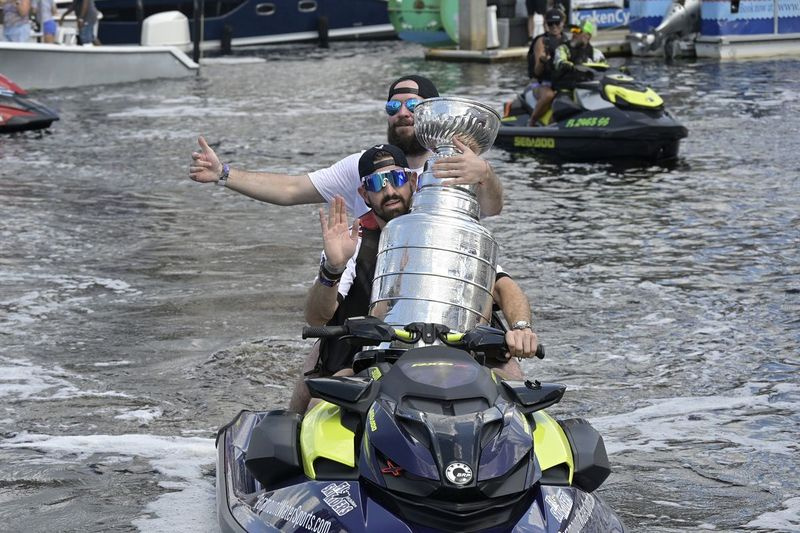 Levo krilo Tampa Bay Lightning Alex Killorn in desno krilo Nikita Kucherov, zadaj, nosita Stanleyjev pokal na osebnem plovilu med praznovanjem parade čolnov.