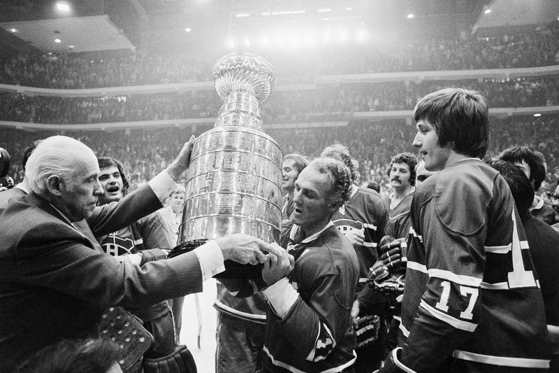 In diesem Aktenfoto vom 10. Mai 1973 überreicht NHL-Präsident Clarence Campbell, links, den Stanley Cup an Kapitän Henri Richard der Montreal Canadiens, nachdem die Canadiens die Blackhawks in Chicago mit 6:4 besiegt hatten. Rechts ist Murray Wilson von den Canadiens.