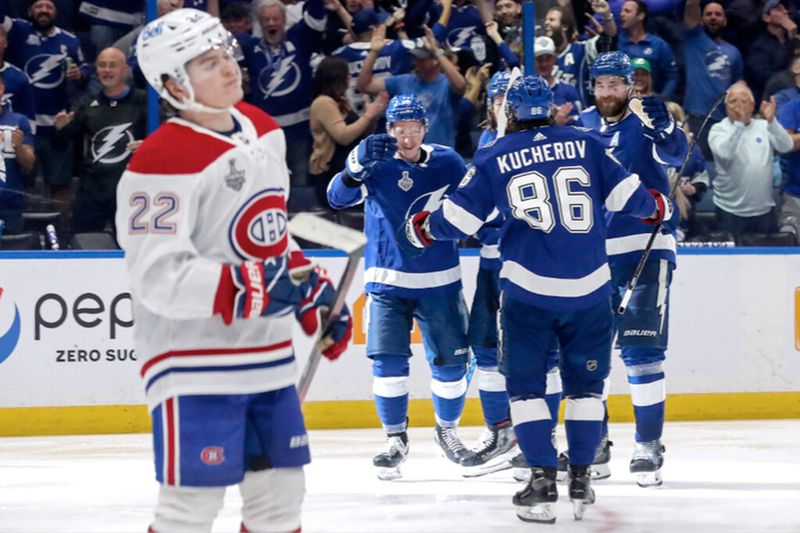 Cole Caufield z Canadiens reaguje znechuceně, když Nikita Kucherov z Lightning oslavuje jeden ze svých dvou gólů se spoluhráči ve třetí třetině.