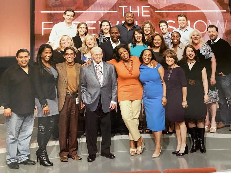 Oprah Winfrey hat einen Arm um Bill Becker gelegt, der auf diesem Foto des Rechtsteams der Harpo Studios in der ersten Reihe in der Mitte neben ihr steht.