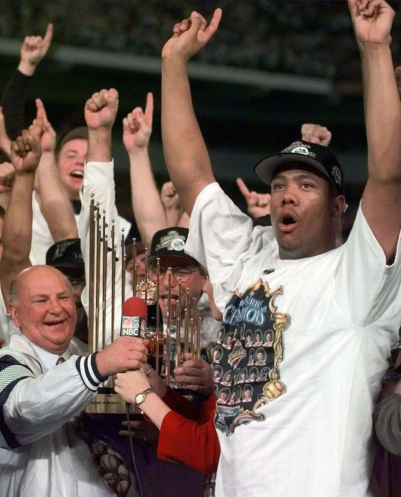 H. Wayne Huizenga, izquierda, con el lanzador de los Marlins de Florida Livan Hernández, sostiene el trofeo de la Serie Mundial después de que sus Marlins de Florida derrotaron a los Indios de Cleveland el 27 de octubre de 1997 para ganar la Serie Mundial. | AP