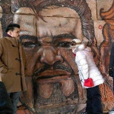 Καλλιτέχνες ζωγράφισαν μια τοιχογραφία κοντά στο 22nd and Central Park με τον πάστορα Βικ. Η σύζυγός του Magdalena θαυμάζει την τοιχογραφία από τα δεξιά. | Παρεχόμενη φωτογραφία