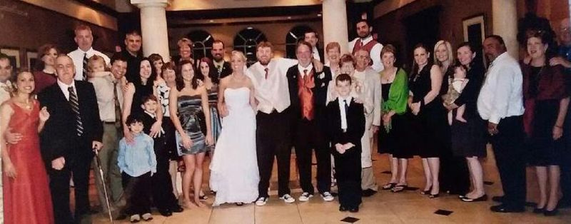 Georgia Sheehan (à direita, de óculos, com as mãos nos ombros de um neto) no casamento de sua neta Erin Durr.