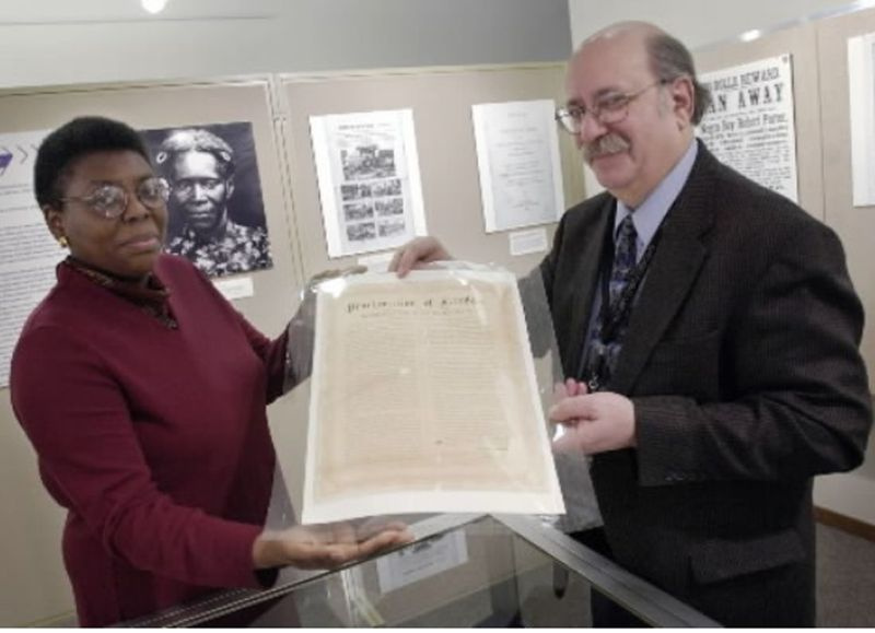 Michael Flug dan pemelihara Denise English mempamerkan cetakan asli Proklamasi Pembebasan Abraham Lincoln menjelang pameran 2004 yang menandakan ulang tahun ke-50 keputusan penting Mahkamah Agung, Brown vs. Lembaga Pendidikan.