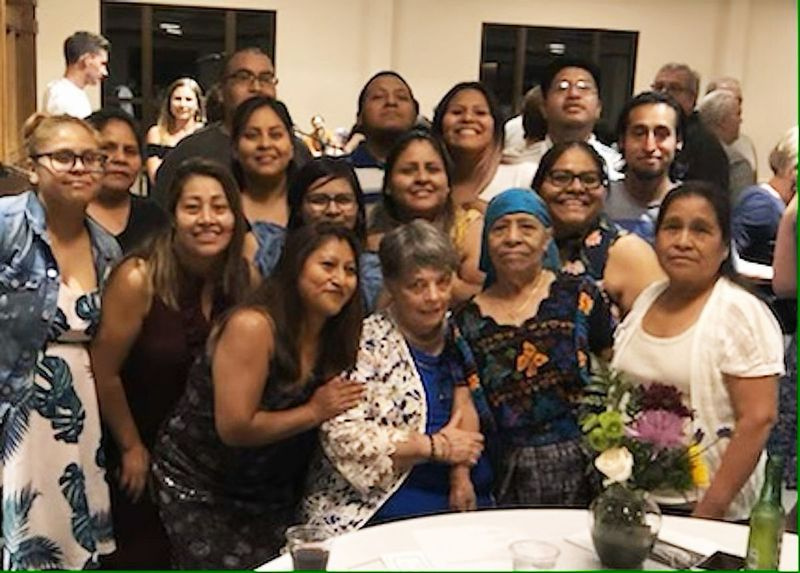 Jan Brent (foran, i midten) omgivet af nogle af folkene fra guatemalansk arv, hun hjalp i USA. Regina Martin læner sig frem for at hvile en hånd på fru Brents skulder.