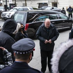 Fr. Dan Brandt, do Ministério dos Capelães do Departamento de Polícia de Chicago, mantém um círculo de oração fora do Escritório de Gerenciamento de Emergências e Comunicações com parentes, colegas de trabalho e apoiadores de Guadalupe Lupe Lopez enquanto sua procissão para na instalação a caminho de seu funeral, na manhã de segunda-feira , 30 de novembro de 2020. Lopez, 58, um despachante do 911 em Chicago por mais de 33 anos, morreu em 16 de novembro de complicações de COVID-19.