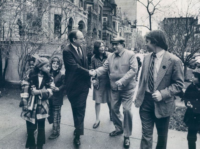 Sur son chemin vers le bureau de vote en 1974, le sénateur Adlai E. Stevenson III (est accueilli par un sympathisant sur North Dearborn. Avec le sénateur sont sa femme, Nancy, et son fils, Adlai IV, à droite, qui a voté pour le première fois ce jour-là.