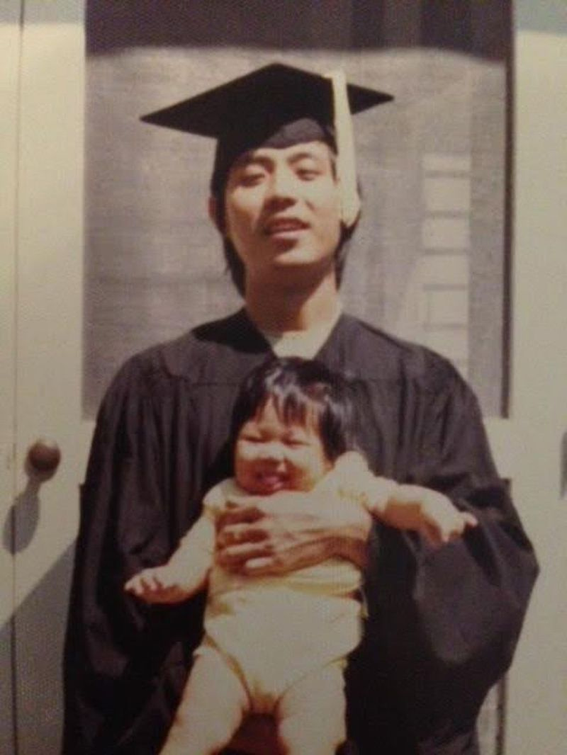 Eddy Cheung segurando sua filha Carol em sua graduação na Universidade Estadual da Carolina do Norte.