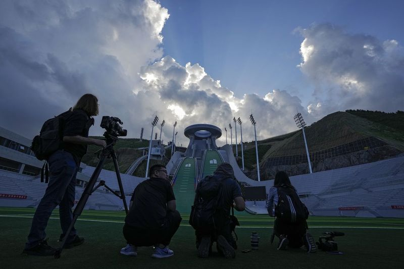 Dziennikarze filmują Narodowe Centrum Skoków Narciarskich, jeden z obiektów Zimowych Igrzysk Olimpijskich i Paraolimpijskich w Pekinie 2022.